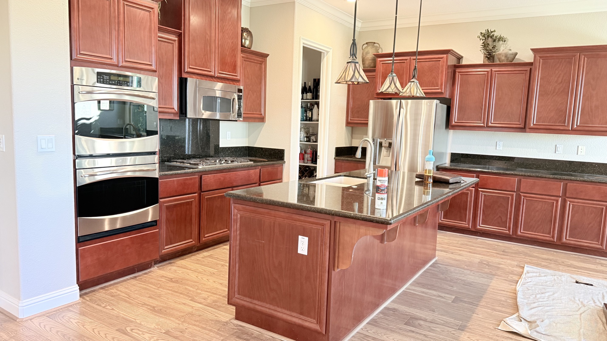 Kitchen before partial remodeling in El Dorado Hills with dark countertops and cherry cabinets
